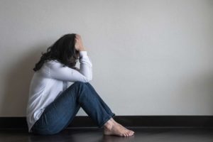 Woman sitting on floor, experiencing the dangers of Xanax bars