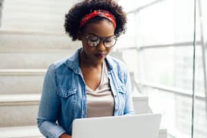 a person sits at a computer researching intensive outpatient program options