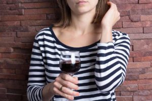a person holds a wine glass find out more signs of Closet alcoholics
