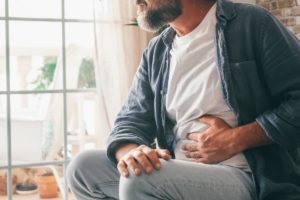 a person holds their stomach after having their Stomach pumped for alcohol