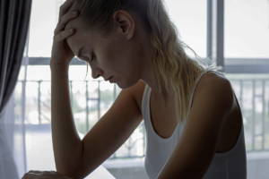 Person near windown thinking about the 5 stages of being drunk