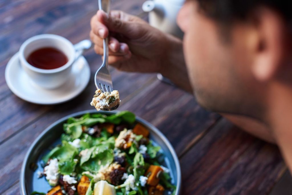 Person eating a nutritious man as they learn how to make their liver healthy