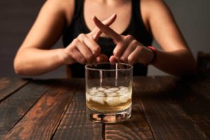 Person with fingers crossed as they demonstrate how they're stopping the effects of wet brain